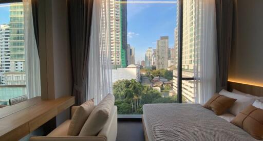 Modern bedroom with city view through large windows