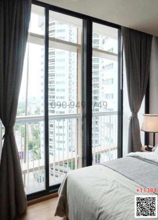 Bright bedroom with floor-to-ceiling windows and city view