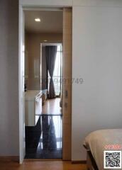 View from a bedroom towards a balcony with daylight coming through the curtains