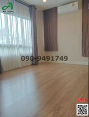 Empty bedroom with hardwood flooring and window with curtains