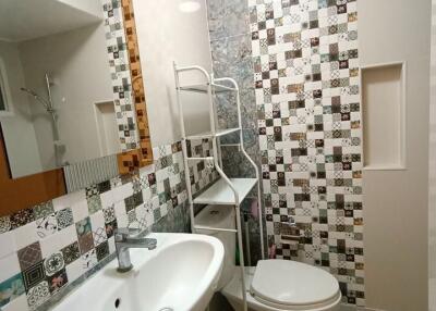 Contemporary bathroom with patterned tile walls, white sanitary ware, and modern amenities