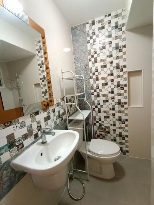 Contemporary bathroom with patterned tile walls, white sanitary ware, and modern amenities