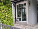 Cozy house entrance with garden fence and patio