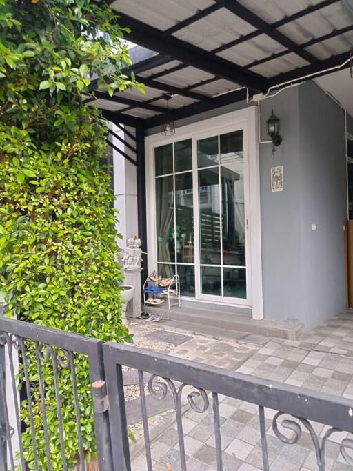 Cozy house entrance with garden fence and patio