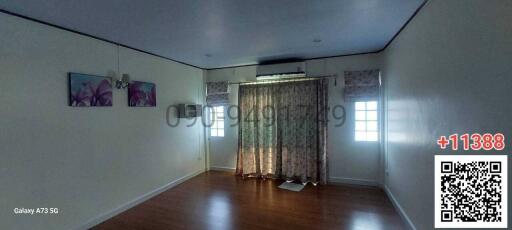 Spacious living room with hardwood flooring and natural light