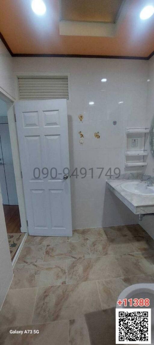 Modern bathroom interior with white fixtures and marble tiles