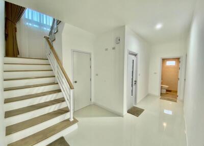 Bright and clean entrance hallway with staircase and multiple doors