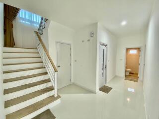 Bright and clean entrance hallway with staircase and multiple doors