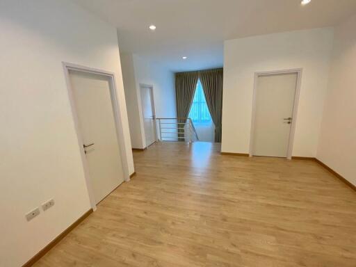 Spacious bedroom with wooden flooring and natural light