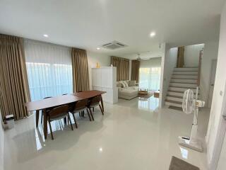 Spacious and modern living room with dining area and staircase