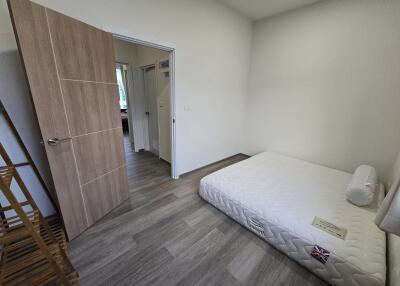 Clean and minimalistic bedroom with a single bed and wooden wardrobe