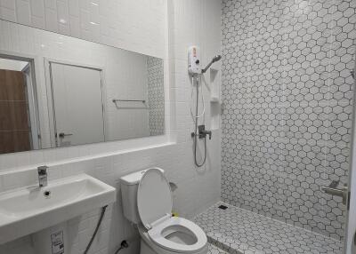 Modern bathroom with white tiles and shower area