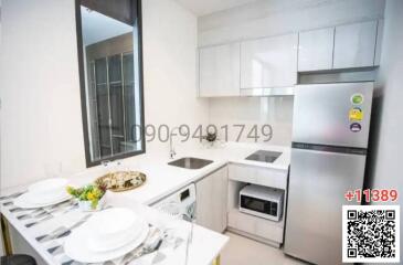 Modern white kitchen with stainless steel appliances and a window