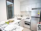 Modern white kitchen with stainless steel appliances and a window