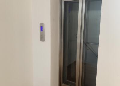 Modern in-building elevator with digital keypad and wooden floor
