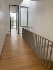 Bright and spacious hallway with hardwood floors and modern railing