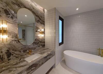 Modern bathroom with marble walls and freestanding tub