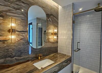 Modern bathroom with textured stone wall and sleek fixtures