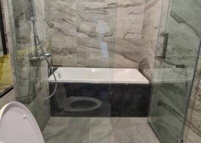 Modern bathroom interior with glass shower and marble tiles