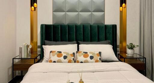 Modern bedroom with a large green upholstered headboard and stylish wall panels