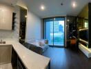 Modern open-concept living space with kitchen, living area, and a glimpse of the bedroom