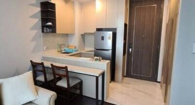 Modern compact kitchen with stainless steel refrigerator