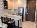 Modern compact kitchen with stainless steel refrigerator