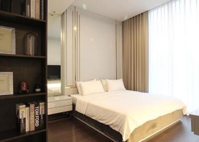 Modern bedroom interior with queen-sized bed and bookshelf