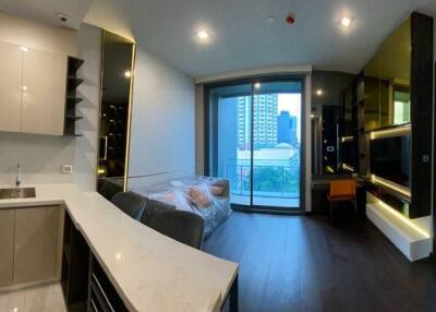 Modern apartment interior with open plan living space featuring kitchen, dining area, and view of the city