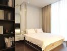 Modern bedroom with king-size bed, shelving units, and natural light