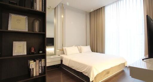 Modern bedroom with king-size bed, shelving units, and natural light