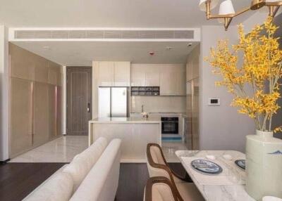 Modern kitchen with integrated living space featuring white decor and elegant furnishings