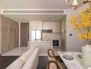 Modern kitchen with integrated living space featuring white decor and elegant furnishings