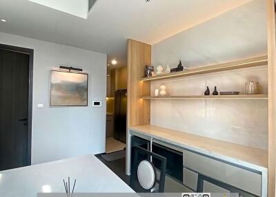 Modern kitchen interior with clean countertop, built-in appliances, and wooden shelves