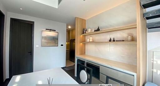 Modern kitchen interior with clean countertop, built-in appliances, and wooden shelves