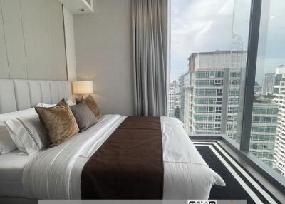 Modern bedroom with large windows overlooking the city