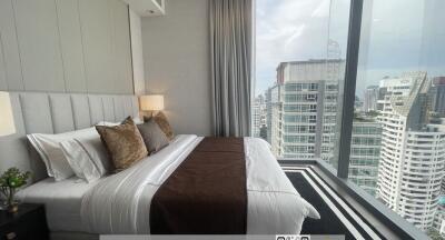 Modern bedroom with large windows overlooking the city