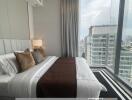 Modern bedroom with large windows overlooking the city