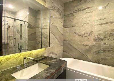 Modern bathroom with elegant stone finishes and well-lit vanity area