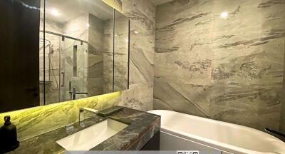 Modern bathroom with marble finishes, and glass shower