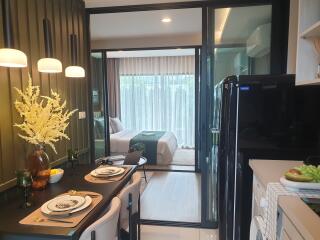 Cozy and modern bedroom with an adjoining balcony visible through sliding glass doors, elegantly set dining table for two, and a sophisticated interior decor