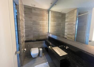 Modern bathroom with sleek design, dual vanity, and glass shower enclosure