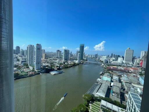 High-rise cityscape view with river and skyline under bright blue sky