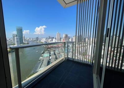 High-rise balcony overlooking a river and cityscape with clear blue sky