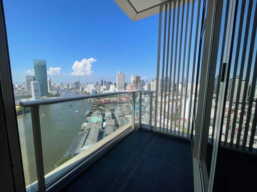 High-rise balcony overlooking a river and cityscape with clear blue sky