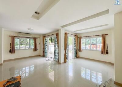 Bright and spacious living room with large windows and tiled flooring