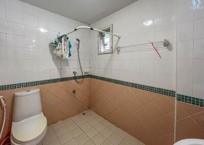 Tiled bathroom with shower and toilet