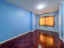 Cozy bedroom with blue walls and hardwood flooring