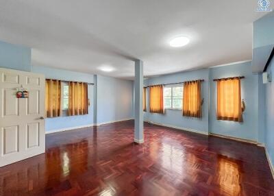Spacious living room with polished hardwood floors and ample natural light