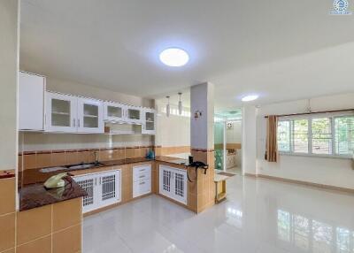 Spacious kitchen with modern white cabinets and tiled flooring